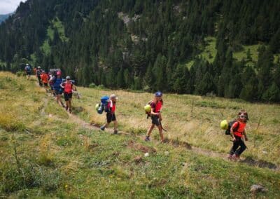 Grupo de excursionistas de distintas edades caminando por senda estrecha en Ordesa